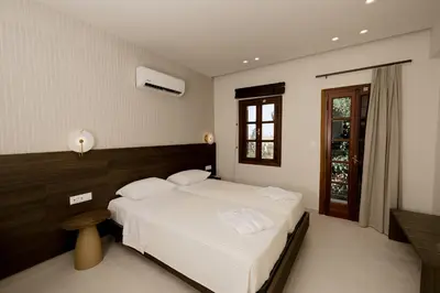 a bedroom with a white bed and a window at Opera House Hotel in Symi