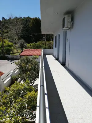 an empty balcony of a white building with trees at Rhodes Paulsia Cosy Apartments in Psinthos