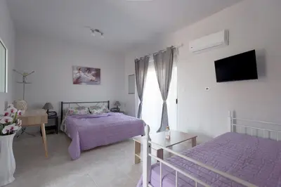 a white bedroom with two beds and a window at Rhodes Paulsia Cosy Apartments in Psinthos