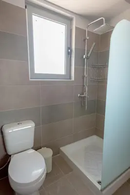 a bathroom with a toilet and a window and a shower at Rhodes Paulsia Cosy Apartments in Psinthos