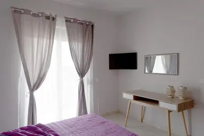 a bedroom with a bed and a desk with a mirror at Rhodes Paulsia Cosy Apartments in Psinthos