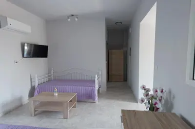 a living room with a purple bed and a table at Rhodes Paulsia Cosy Apartments in Psinthos
