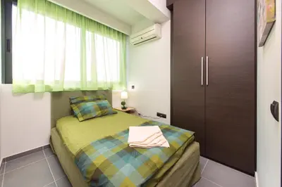 a small bedroom with a bed and a cabinet at Filerimos Garden Villa in Ialyssos