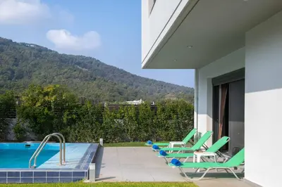 a patio with lounge chairs and a swimming pool at Filerimos Garden Villa in Ialyssos
