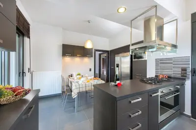 a kitchen and dining room with a table in the background at Filerimos Garden Villa in Ialyssos