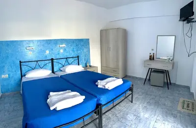 a blue bedroom with a blue bed with white pillows at Kedros Rooms in Prasonisi