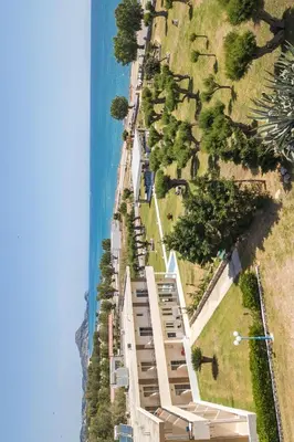 a building on the side of a hill next to the ocean at Al Mare Apartments in Afantou