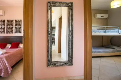 a mirror on a wall next to a bedroom at Al Mare Apartments in Afantou