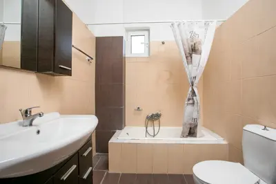 a bathroom with a sink and a tub and a toilet at Al Mare Apartments in Afantou