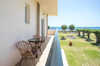 a balcony with chairs and a view of the ocean at Al Mare Apartments in Afantou