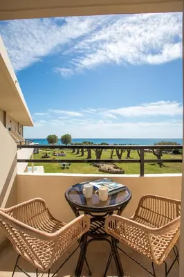 a balcony with a table and chairs and a view of the ocean at Al Mare Apartments in Afantou