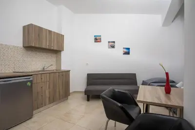 a kitchen with a couch and a table and chairs at Al Mare Apartments in Afantou