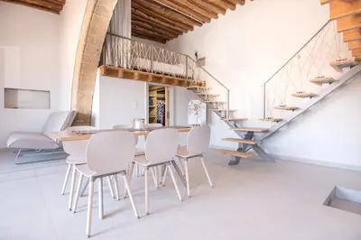 a dining room with a wooden table and white chairs at Villa Acacia in Phanaes