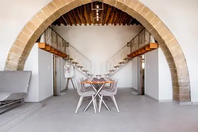 a dining room with an archway and a table and chairs at Villa Acacia in Phanaes