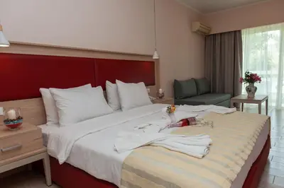 a hotel room with a bed with towels on it at Filerimos Village Hotel in Ialyssos
