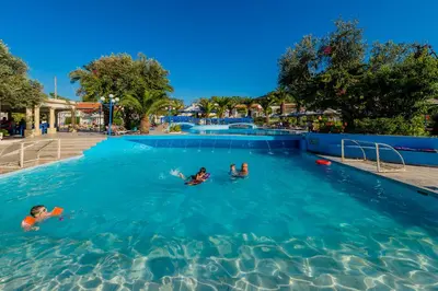 a group of people swimming in a swimming pool at Filerimos Village Hotel in Ialyssos
