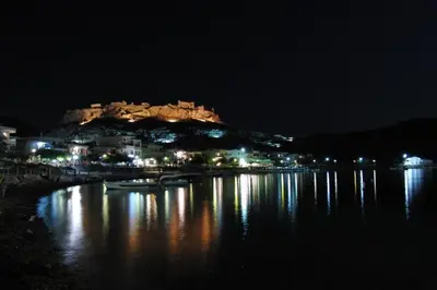 a night view of a town with a castle on a hill at Castle View Apartments in Haraki