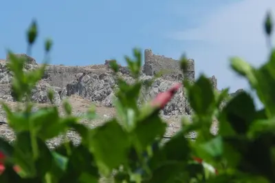 a castle on top of a hill with green vegetation at Castle View Apartments in Haraki
