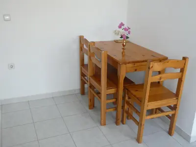a wooden table and chairs with a vase of flowers on it at Castle View Apartments in Haraki