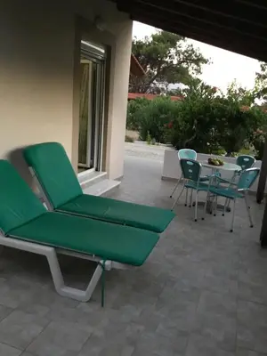 a patio with a green chair and a table and chairs at VILLA EIRINI in Pefki Rhodes