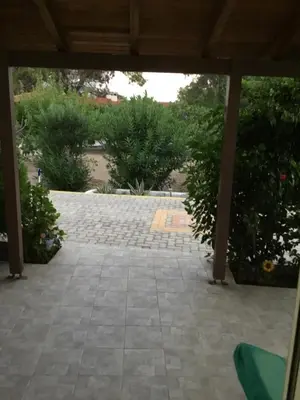an outdoor patio with a stone floor and bushes at VILLA EIRINI in Pefki Rhodes