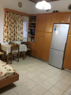 a kitchen with a refrigerator and a table at VILLA EIRINI in Pefki Rhodes