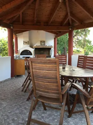a patio with a table and chairs and a stove at VILLA EIRINI in Pefki Rhodes