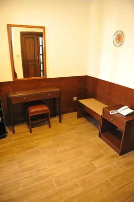 a room with a bench and a table and a mirror at Niki Hotel Apartments in Ialyssos