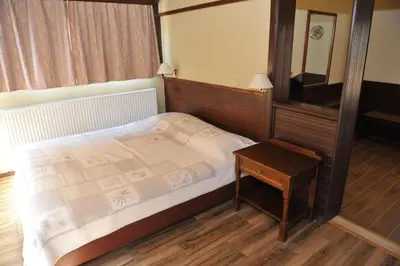 a bedroom with a bed and a table and a mirror at Niki Hotel Apartments in Ialyssos