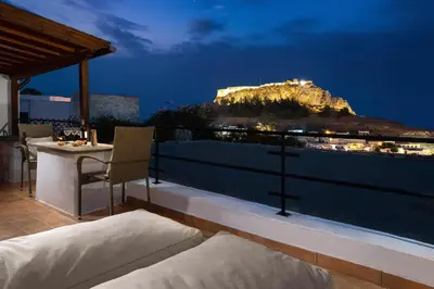 a balcony with a view of a mountain at night at Villa Valasia Lindos with Acropolis View in Líndos