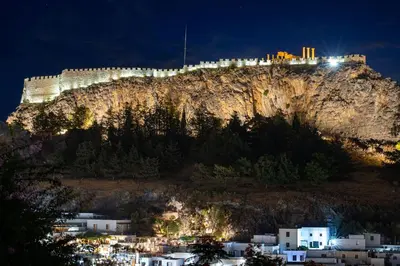 a castle on top of a mountain at night at Villa Valasia Lindos with Acropolis View in Líndos