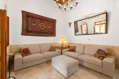 a living room with two couches and a mirror at Villa Valasia Lindos with Acropolis View in Líndos