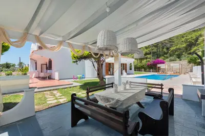 an external view of a villa with a table and a pool at Una Villa Rhodes in Ixia