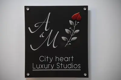 a sign for a city heart library studios with a red rose at City Heart Luxury Studio Aurora in Rhodes Town