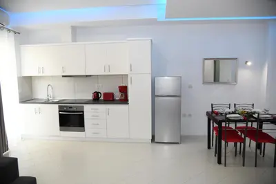 a white kitchen with a table and a refrigerator at City Heart Luxury Studio Aurora in Rhodes Town