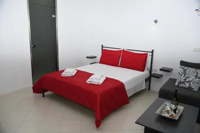 a bedroom with a red and white bed and a couch at City Heart Luxury Studio Aurora in Rhodes Town