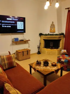 a living room with a fireplace and a tv at Mata's Sea House in Lachania