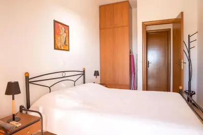 a bedroom with a white bed and a wooden door at Mata's Sea House in Lachania
