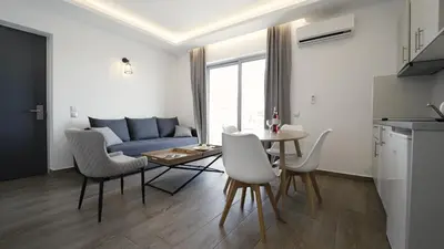 a living room with a table and a blue couch at Sunrise Luxury Apartments Rhodes in Rhodes Town