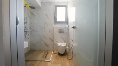 a bathroom with a toilet and a window at Sunrise Luxury Apartments Rhodes in Rhodes Town
