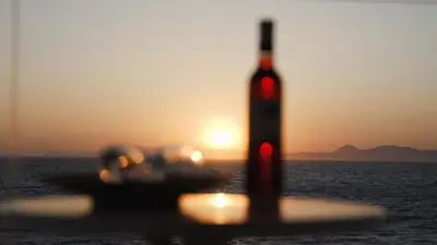 a bottle of wine sitting on top of the ocean at Sunrise Luxury Apartments Rhodes in Rhodes Town