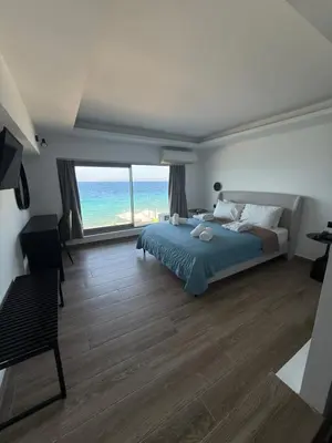 a bedroom with a bed and a view of the ocean at Sunrise Luxury Apartments Rhodes in Rhodes Town