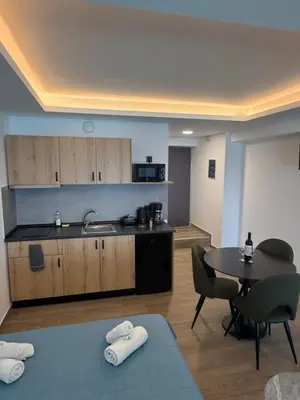 a kitchen with a table and a sink and a table and chairs at Sunrise Luxury Apartments Rhodes in Rhodes Town