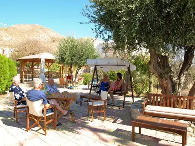a group of people sitting in chairs under a canopy at Castellania Hotel Apartments in Livadia