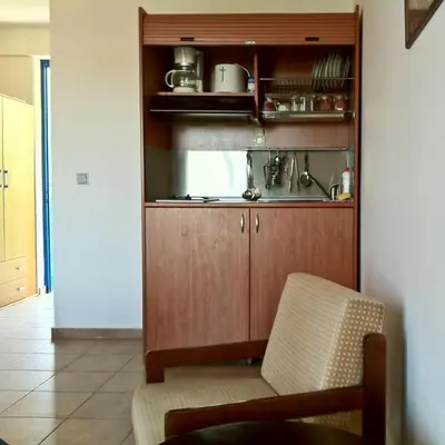a kitchen with a sink and a chair in a room at Castellania Hotel Apartments in Livadia