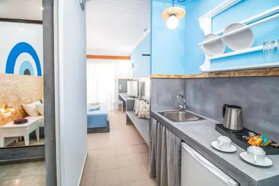 a kitchen with a sink and a living room at Tinas Plus Hotel in Faliraki