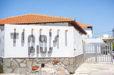 a sign on the side of a building with a fence at Tinas Plus Hotel in Faliraki