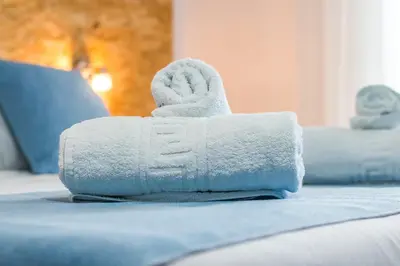 a pile of towels sitting on top of a bed at Tinas Plus Hotel in Faliraki
