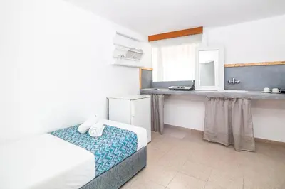 a bedroom with a bed and a sink in it at Tinas Plus Hotel in Faliraki