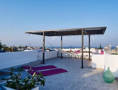 a rooftop deck with a hammock and yoga mats at Kalithea Hills Appartment 1 in Koskinou